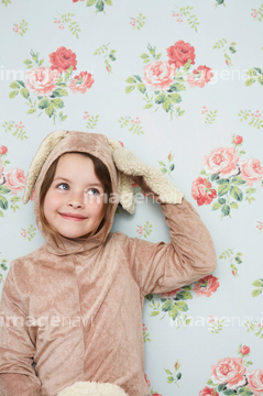 Portrait of young girl (5,6) in bunny costume touching ear, wallpaper