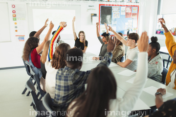 Junior high school students enjoying lesson at desks in classroom