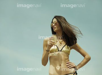 Skinny female model wearing bikini standing against white