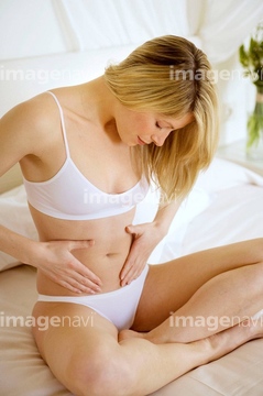 Fanciful young woman in swimsuit is laughing looking down at