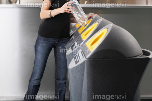 Woman recycling a plastic bottle