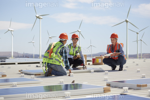 Engineers installing solar panels at alternative energy power plant