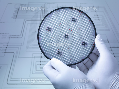 Gloved hands holding silicon wafer in laboratory, close up