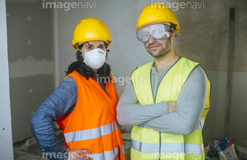 Portrait of woman with mask and man with safety glasses on a construction site