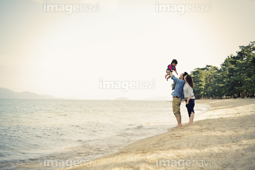 Parents lifting daughter mid air on beach