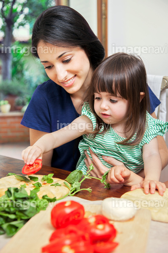 Mother and daughter making homemade pizza